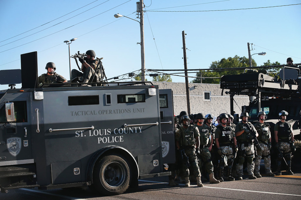 Police stand watch as demonstrators protest the shooting death of teenager Michael Brown on August 13, 2014 in Ferguson, Missouri.